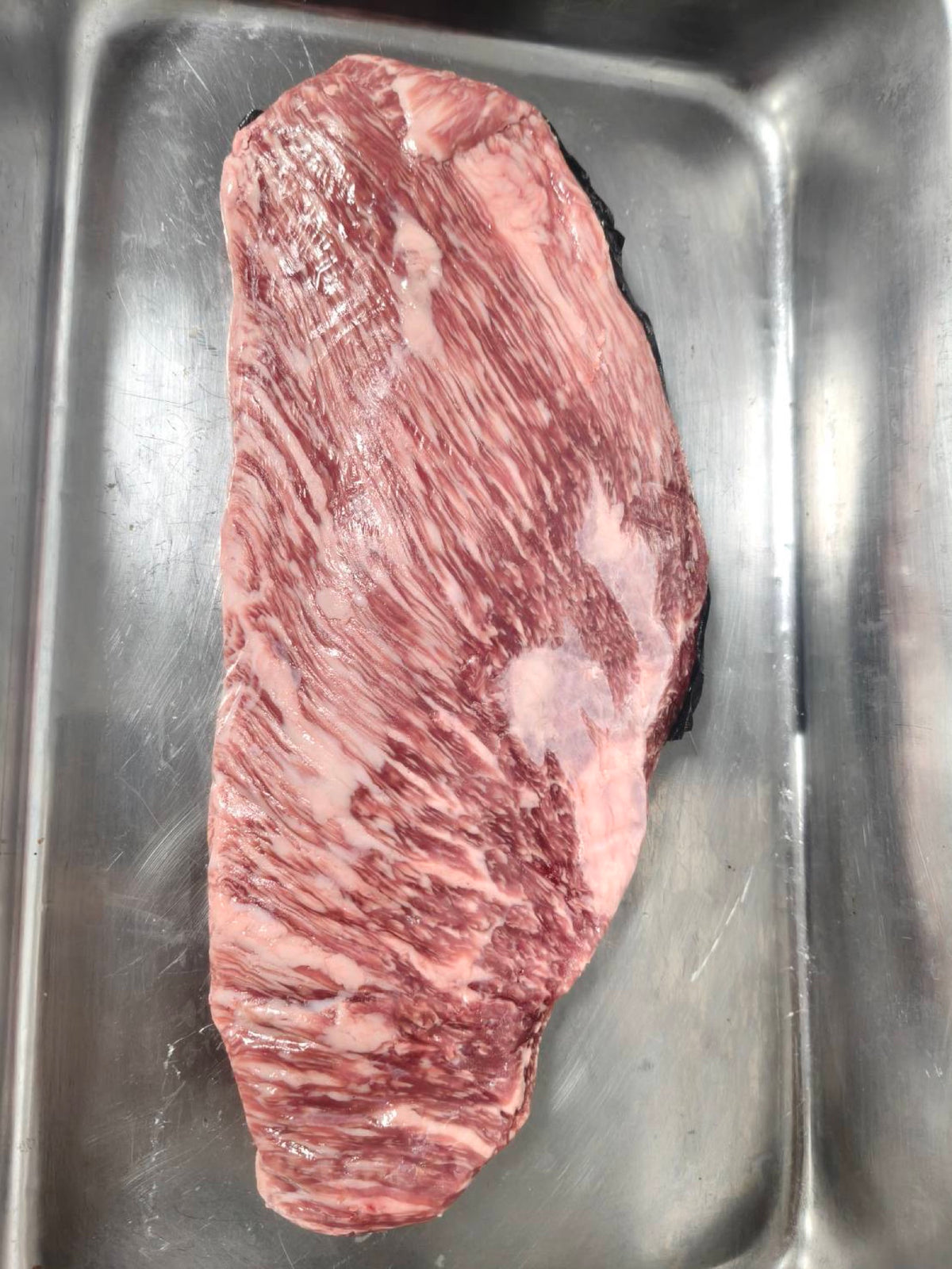 Marble King Wagyu ribeye cap MB9+, raw whole cap on steel tray